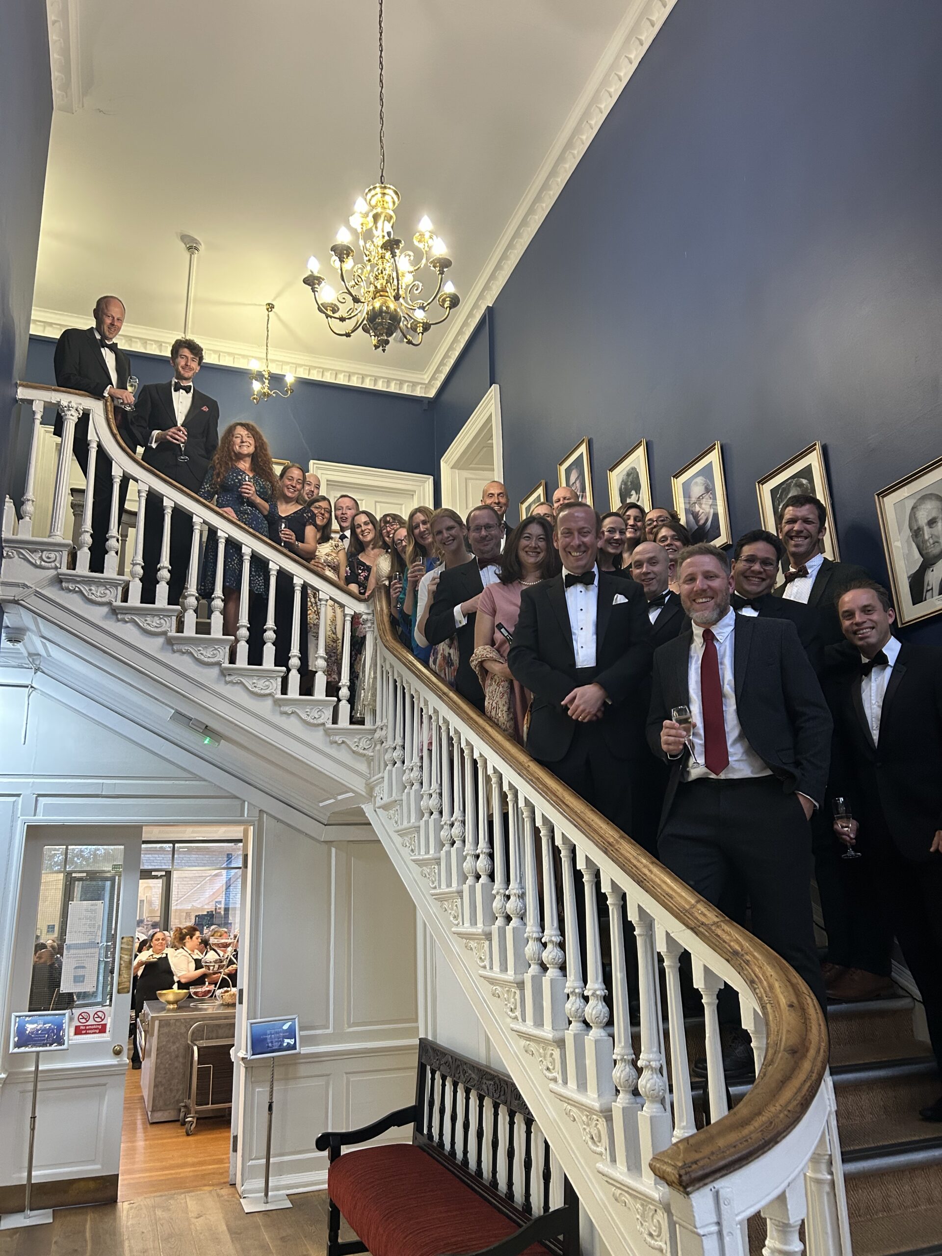 a group of people in formal dress on a stair case