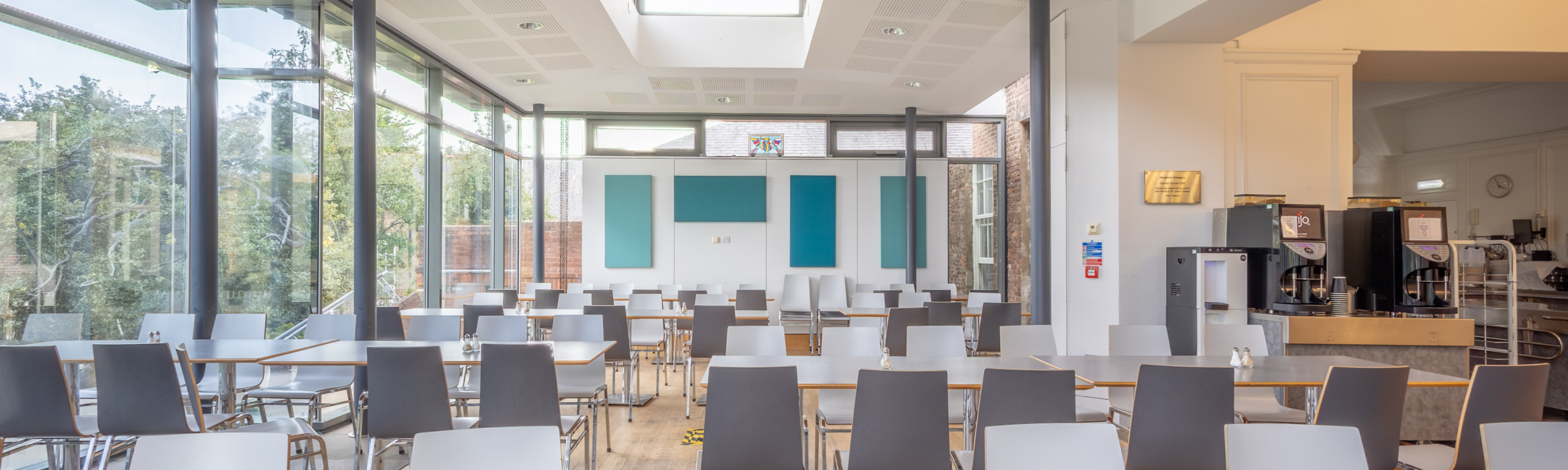 The modern dining space of St John's College, with garden view and view of servery area