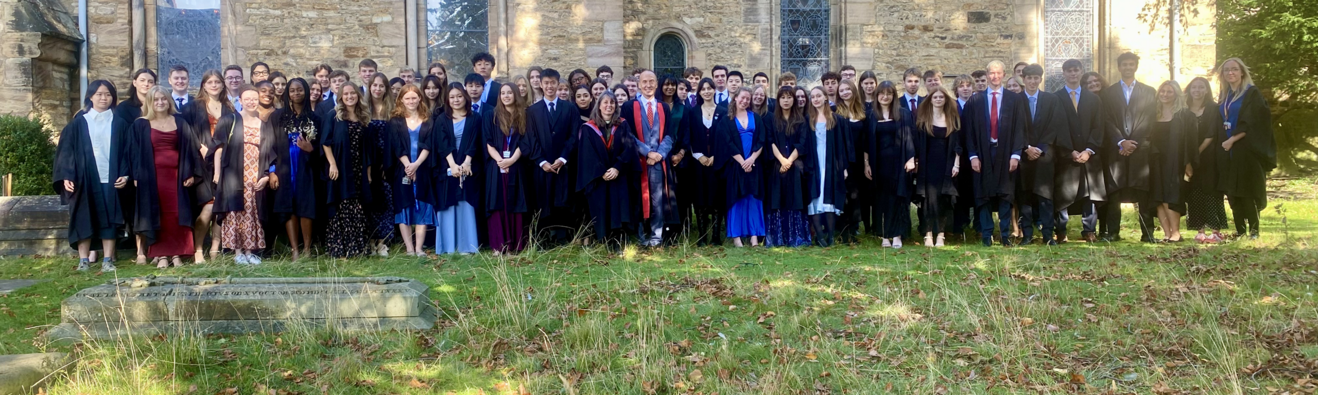 Undergraduate students gathered with academic gowns outside St Mary the Less