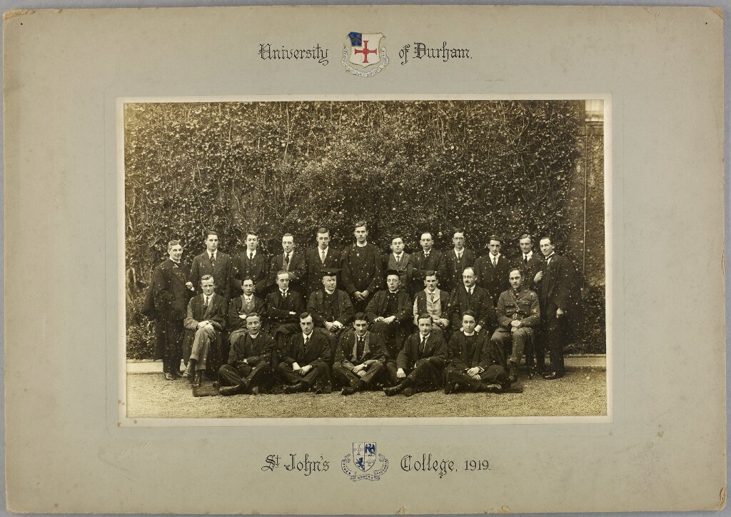 class photo in black and white the group wears academic dress and many have clerical collars