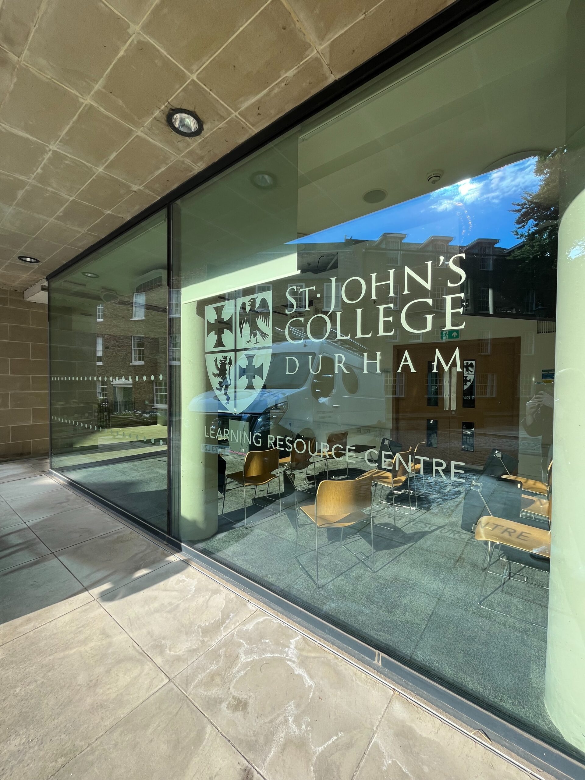 a floor to ceiling window with the St John's crest