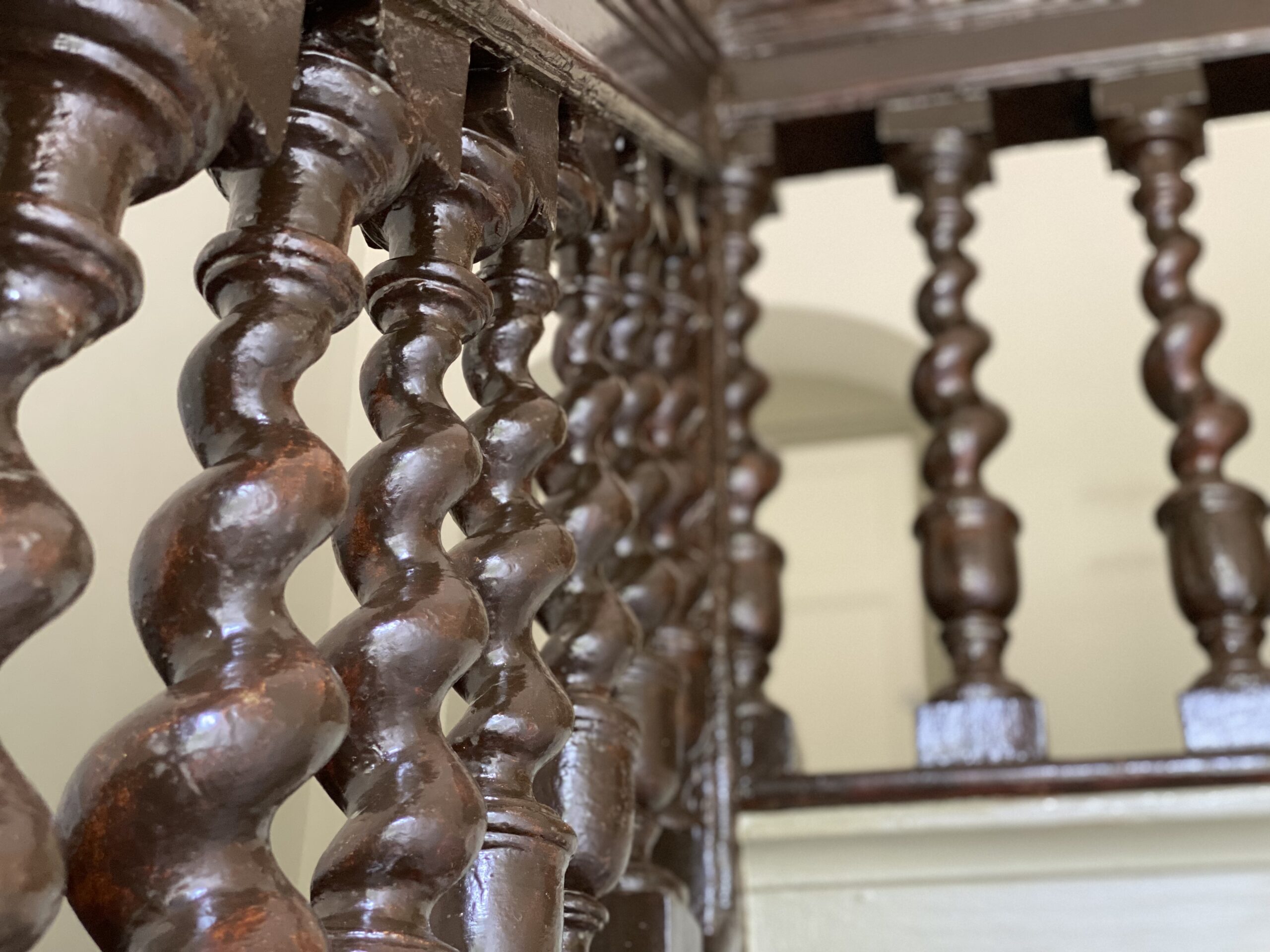 dark wooden stair case with curling spindles
