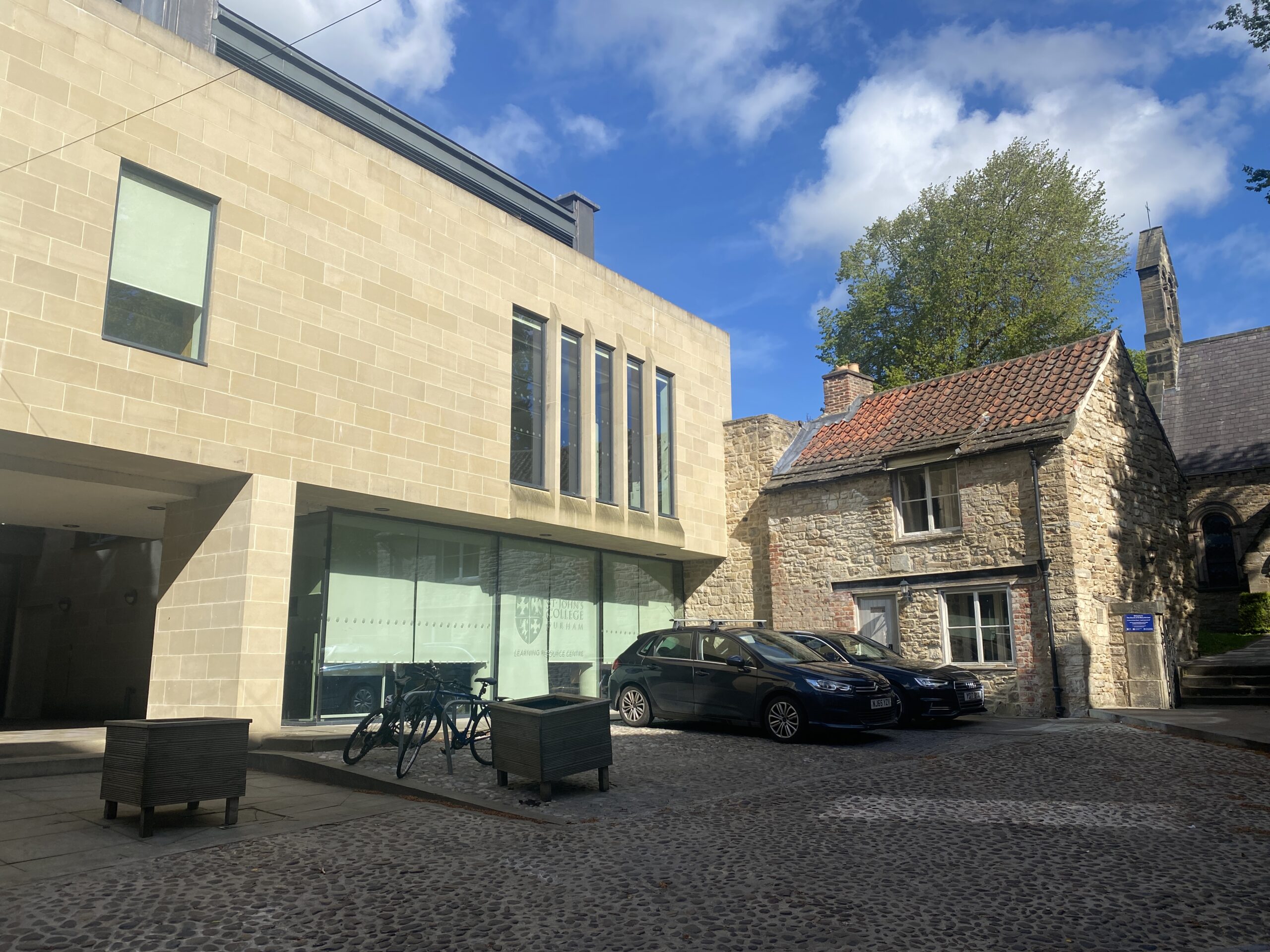 A modern sandstone building under a bright blue sky