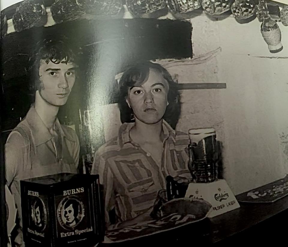 a young man and a young woman pull pints
