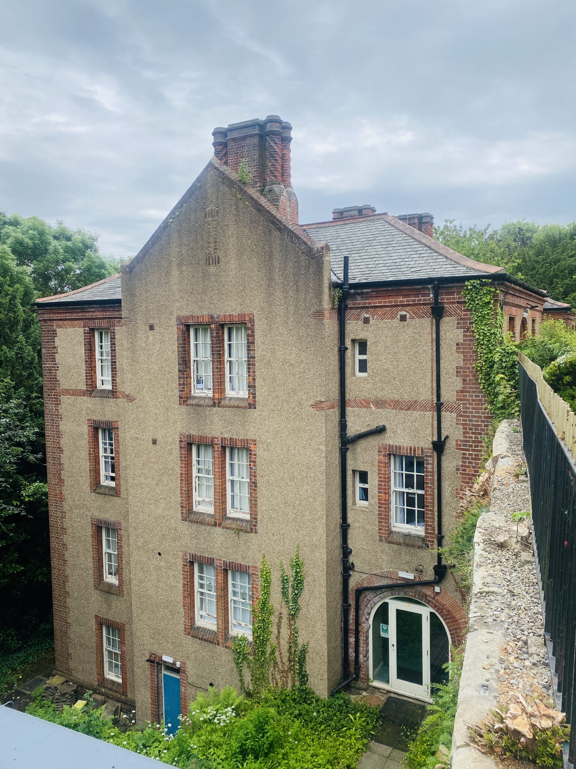 a four story building with brick chimneys under a grey sky