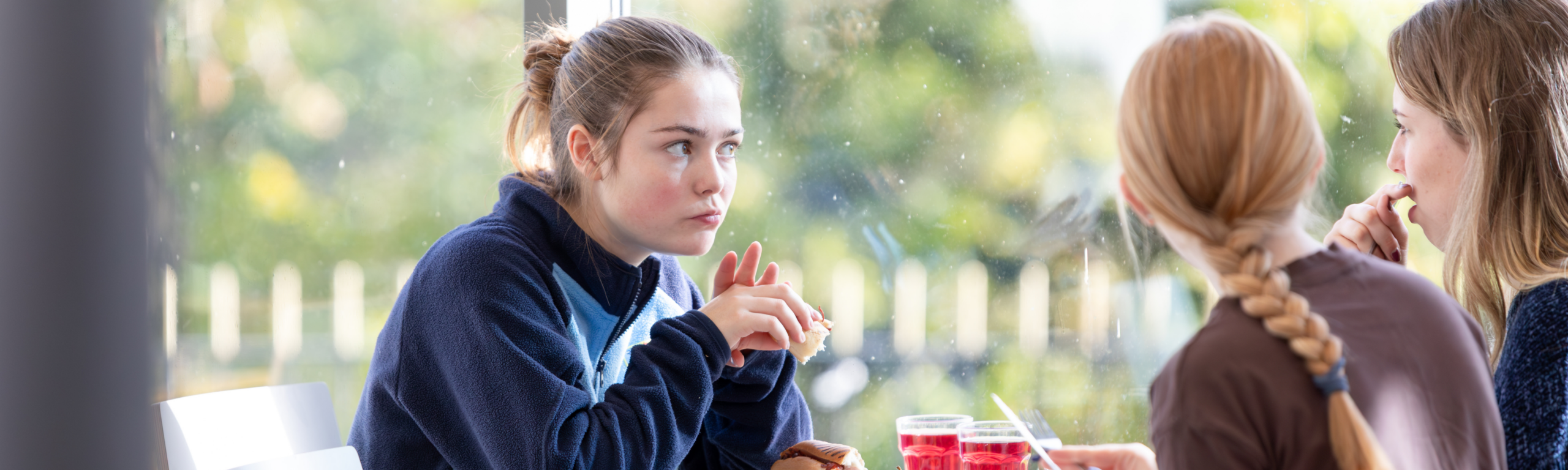 Three female students talking over lunch